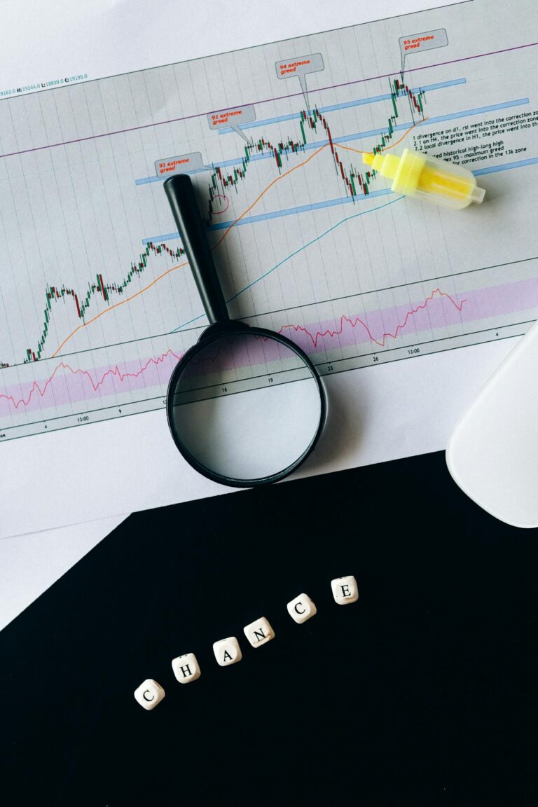 A conceptual still life of a stock chart with magnifying glass and 'chance' text.